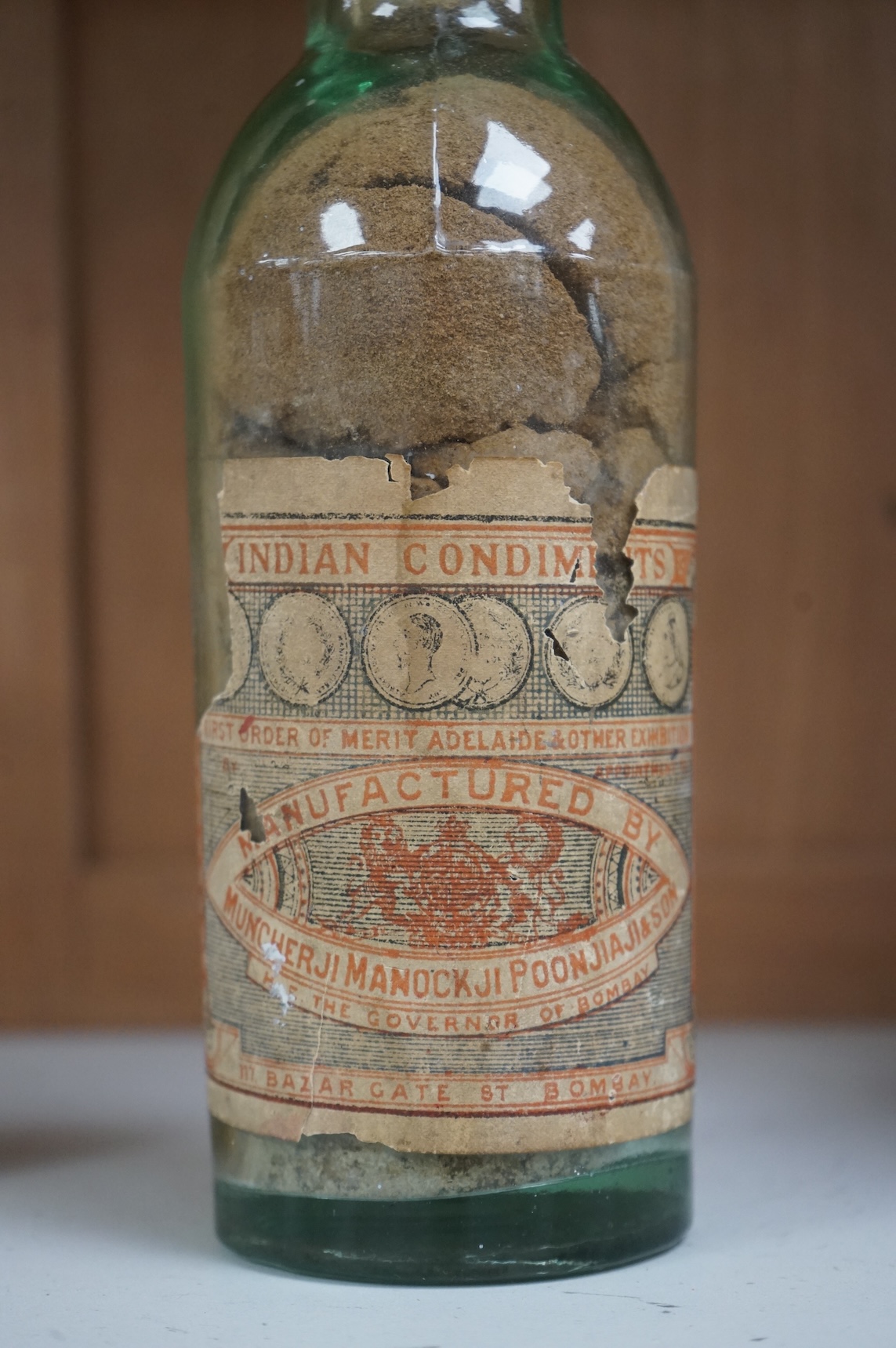 A 19th century sealed bottle of Indian curry powder, with original labels, 28cm high